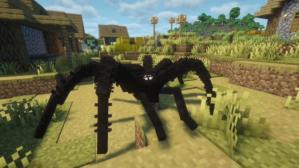 マインクラフトの村の広場に現れた、ArPhEx Modの巨大な黒蜘蛛。全身が漆黒で、村の道を塞ぐほどの大きさがあり、無数の脚と白く光る目が特徴。背景には村の家屋や干し草の山が見える。