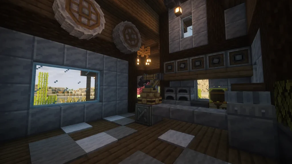 Minecraftの工業化Mod「Create」を用いた自動化拠点の内部。石と木材で構成された2層構造の部屋で、天井付近には大きな歯車（Great Gearing）が並び、1階の中央には自動化された大釜（Blaze Burner付き）と調理設備、石の作業台が設置されている。窓からは屋外のサトウキビ畑が見える。