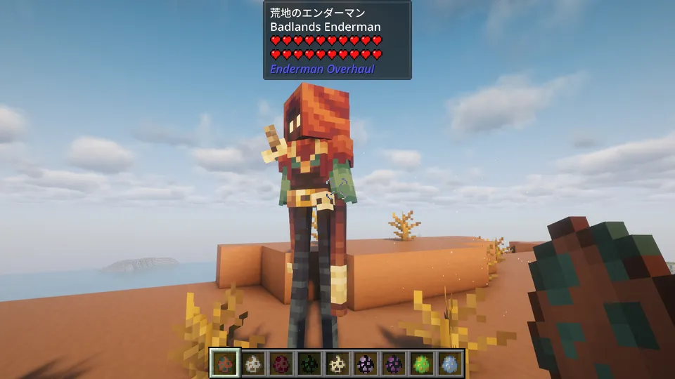 Enderman Overhaul Modの「荒地のエンダーマン（Badlands Enderman）」。乾燥した荒野（メサ）バイオームに合わせ、赤茶色のフード付きローブを纏い、腰には骨のようなアクセサリーを下げている。旅人のような風貌をした、細身で背の高いエンダーマン。