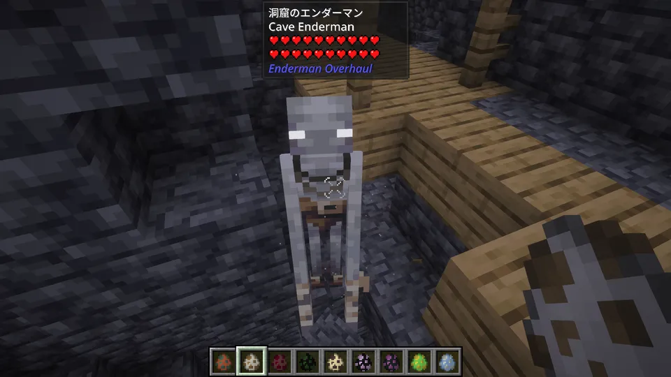 Enderman Overhaul Modの「洞窟のエンダーマン（Cave Enderman）」。光の届かない洞窟に適応した、全身が石のように白い体色が特徴。暗い地下通路でプレイヤーを見つめる、少し不気味で原始的な姿のエンダーマン。