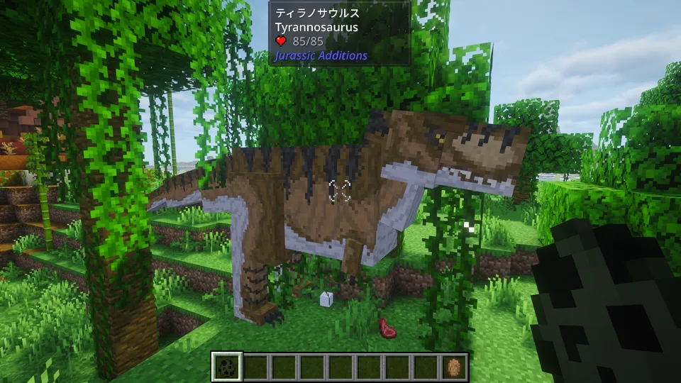 Jurassic Additions Modの「ティラノサウルス（Tyrannosaurus）」。ジャングルの木々の間に現れた、茶色の鱗と鋭い牙を持つ巨大な肉食恐竜。マインクラフトのブロック感を生かしつつ、圧倒的な存在感と威圧感を持つデザイン。