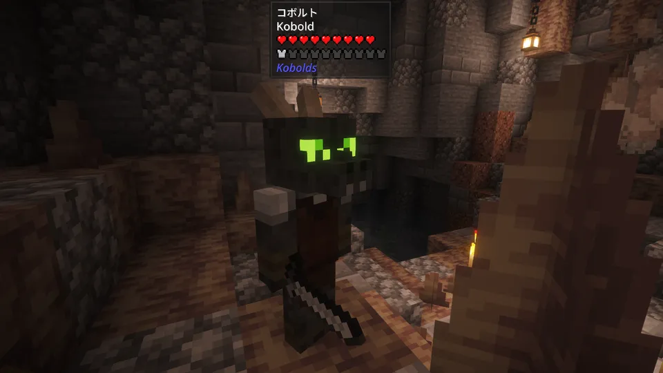 Kobolds Modに登場する「コボルトの付与師（Kobold Enchanter）」。石レンガの建物内で、緑色に光る目と頭のツノが特徴的な小さなトカゲ人間の姿。赤い服を纏っており、画面上部にはMod独自の体力バーが表示されている。