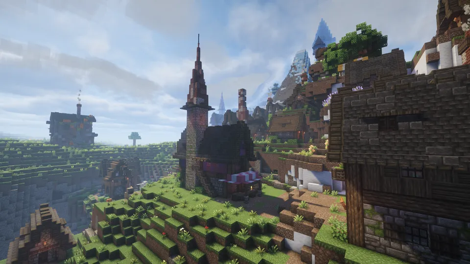 Minecraft Mod「Medieval MC」で生成された中世風の村の遠景。丘に沿って石造りと木造の建物が並び、影モッド（シェーダー）によるリアルな光と青空が、ファンタジーRPGのような美しい景観を作り出しています。
